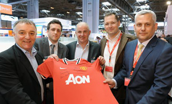 Lou Macari (far left) and Arthur Albiston (centre) present a signed jersey on Hybrid's stand 1